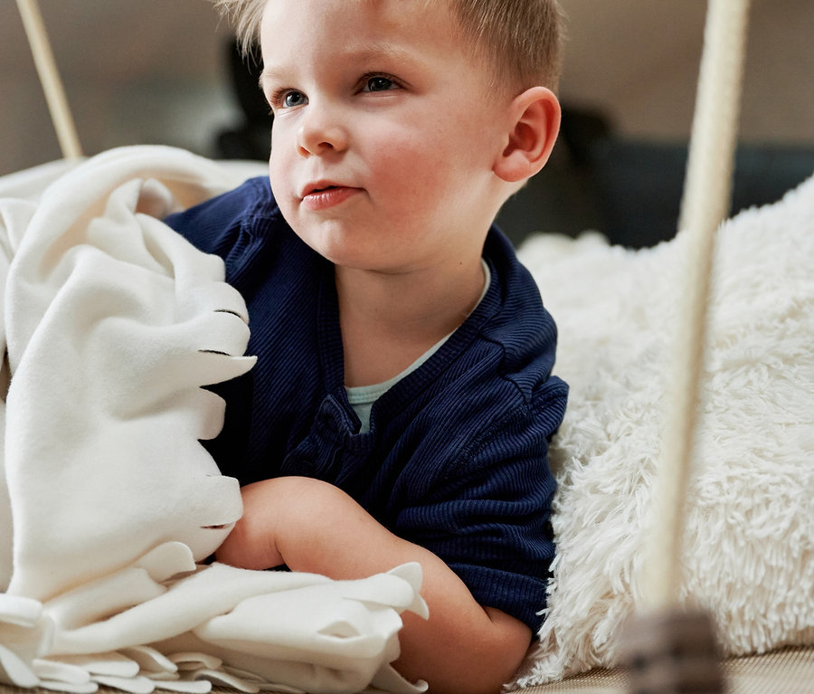 Junge liegt in HUDORA Nestschaukel »Lounge«, midnight, Ø 110 cm mit weicher Decke.