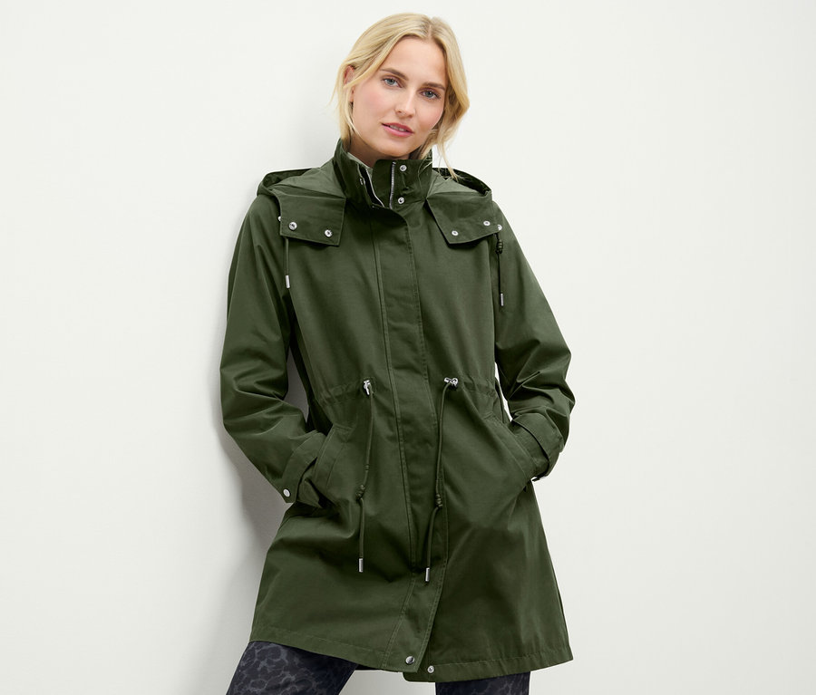 Frau trägt eine grüne Parka mit Kapuze.