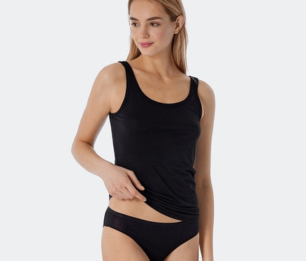 Frau trägt zwei schwarze, gestreifte SCHIESSER Trägertops mit Modal.