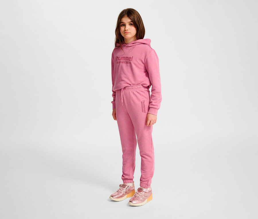 Mädchen trägt rosa HUMMEL HMLJR Base Regular Pants und Hoodie.