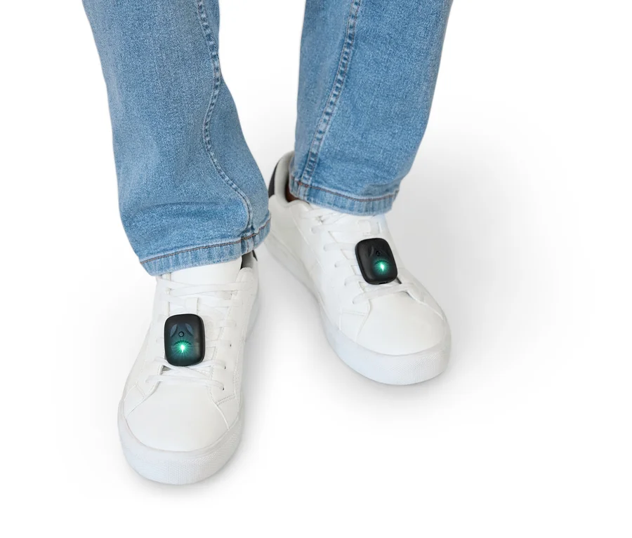 Beine in Jeans und weißen Schuhen mit schwarzen Sensoren mit LEDs.