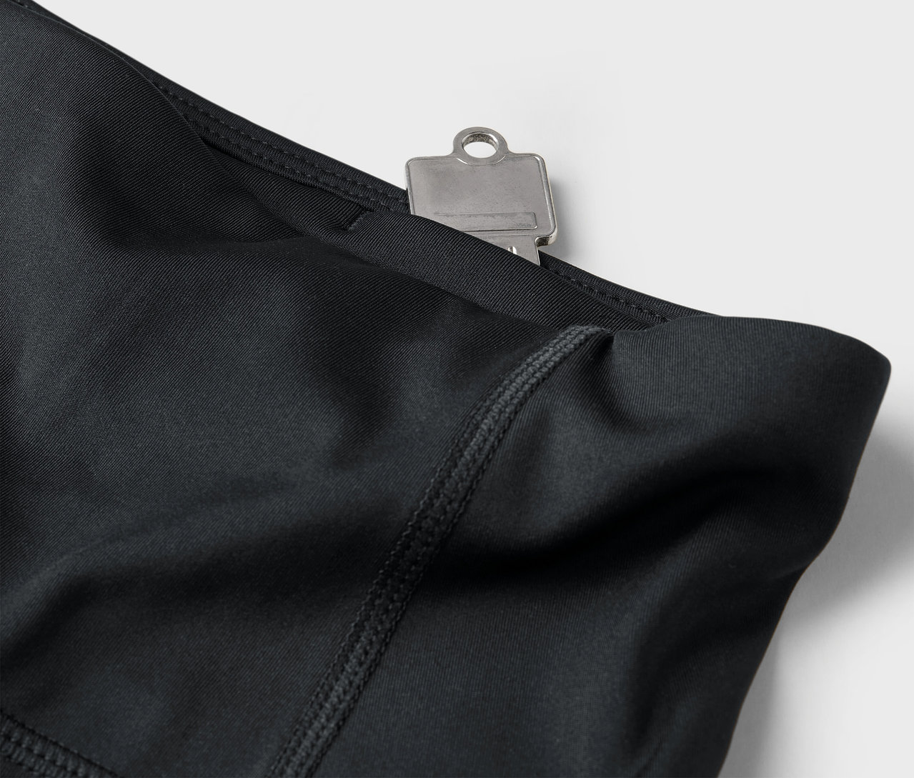 Detailaufnahme von schwarzen Leggings mit Schlüssel in der Tasche.