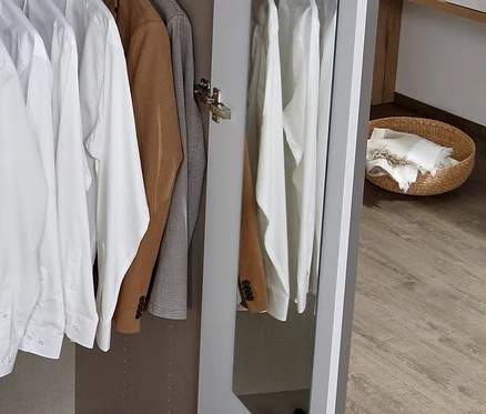 Offener Schrank mit Kleidung, Tasche und Schuhen.