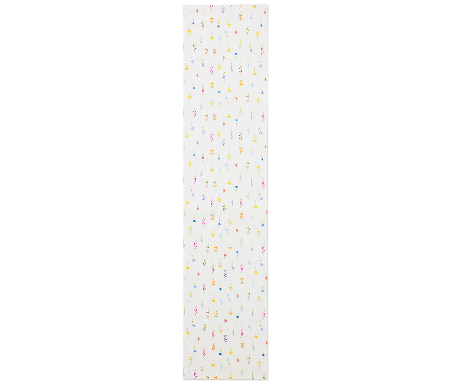 Ein Tischläufer mit einem Blumenmuster in Gelb, Blau, Rosa und Rot auf einem weißen Hintergrund.