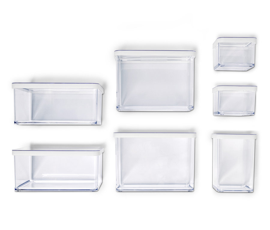 Sieben leere, durchsichtige Aufbewahrungsbehälter mit weißen Deckeln unterschiedlicher Größe sind auf einem weißen Hintergrund angeordnet.