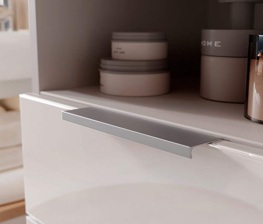 Aufnahme eines Badezimmerschranks mit Cremetiegeln und einer braunen Duftkerze.