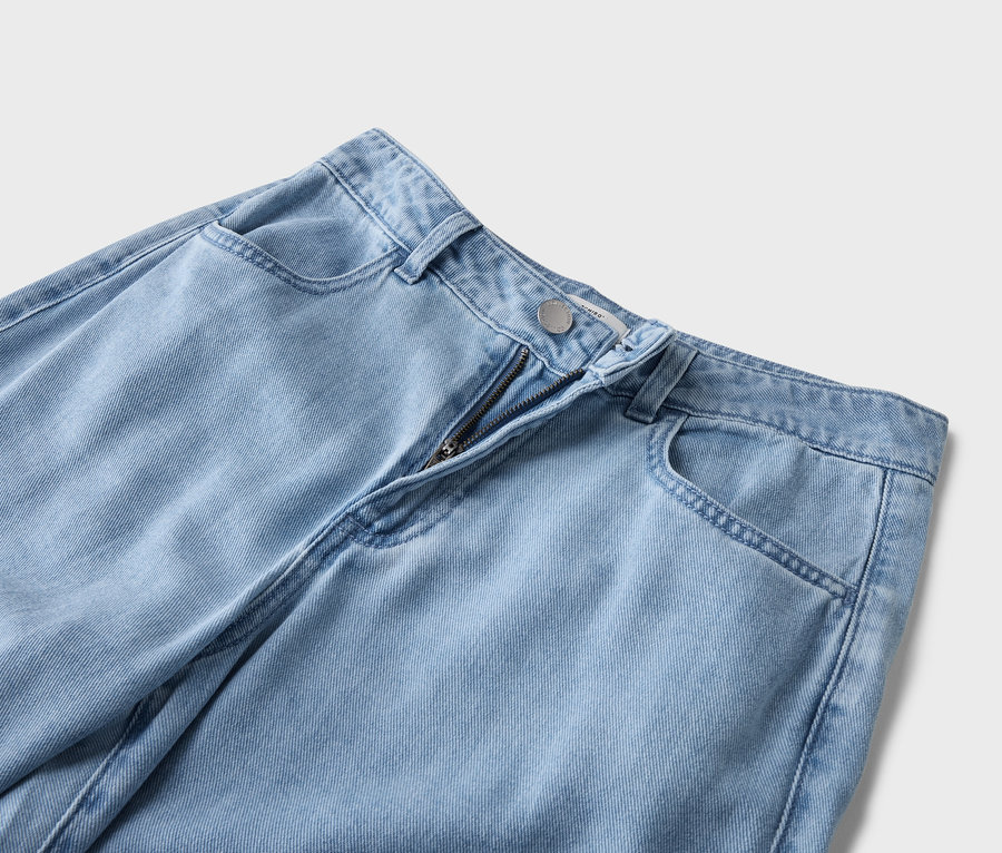 Detailansicht einer hellblauen Jeans mit sichtbarem Reißverschluss und Taschen.