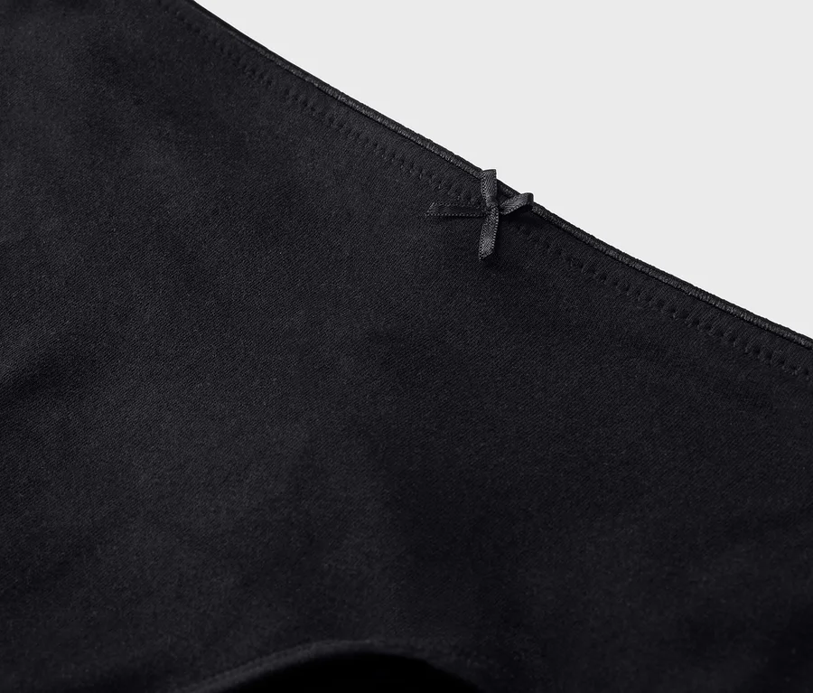 Nahaufnahme einer schwarzen Unterhose mit einer kleinen Schleife am Bund.