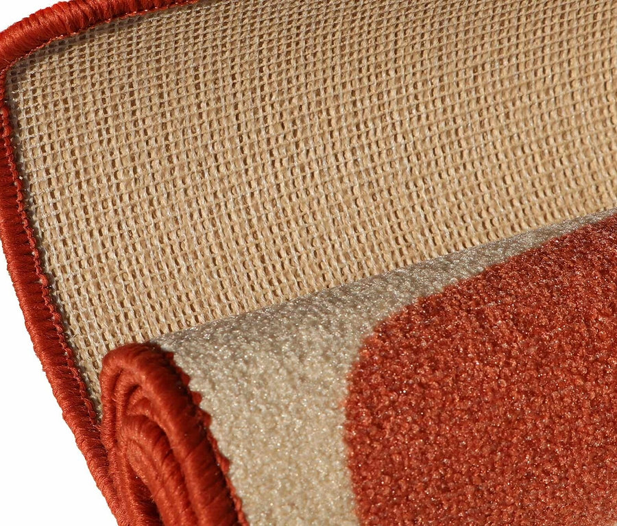 Detailansicht eines teilweise aufgerollten Kinderteppichs »Rainbow« im Vintage-Stil mit orangefarbenen Akzenten.