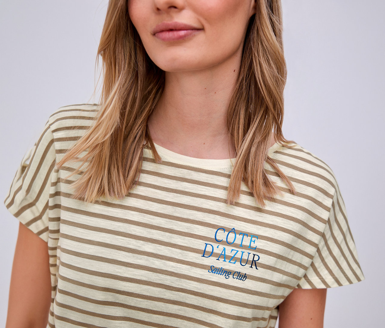 Frau trägt ein beige-weißes Street One T-Shirt mit Streifen und blauem "Côte d'Azur"-Aufdruck.