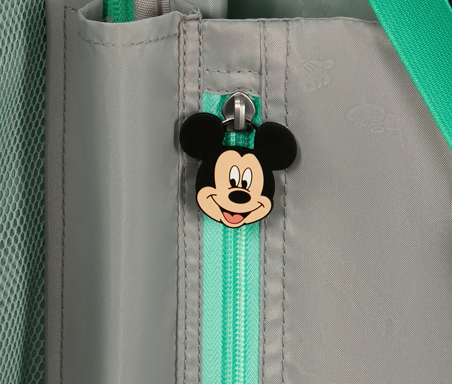 Nahaufnahme eines grauen Koffers mit einem hellgrünen Reißverschluss und einem Mickey-Mouse-Anhänger.
