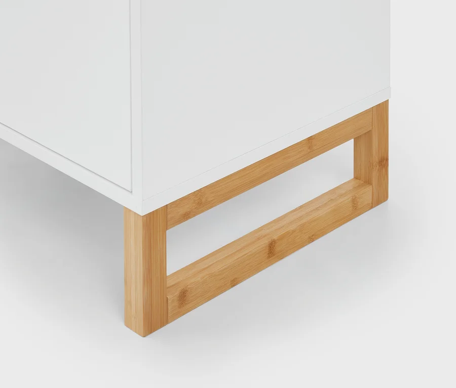 Weißer Schrank mit Bambusbeinen, der den unteren Teil und den Holzrahmen zeigt.