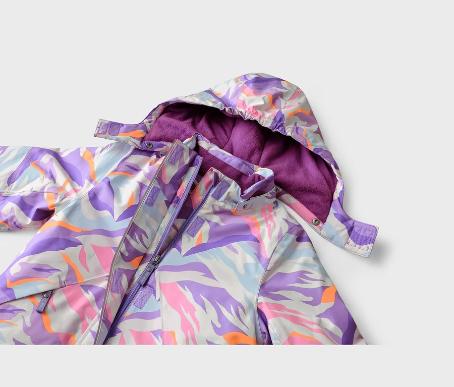Nahaufnahme einer Jacke mit einem lebhaften abstrakten Muster in Lila, Pink, Orange, Hellblau und Weiß. Die Kapuze ist mit lila Fleece gefüttert, und ein lila Reißverschluss ist vorne sichtbar.