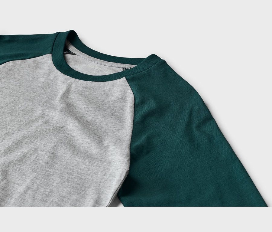 Nahaufnahme eines Langarmshirts mit grauem Rumpf und dunkelgrünen Raglanärmeln sowie einem dunkelgrünen Rundhalsausschnitt.