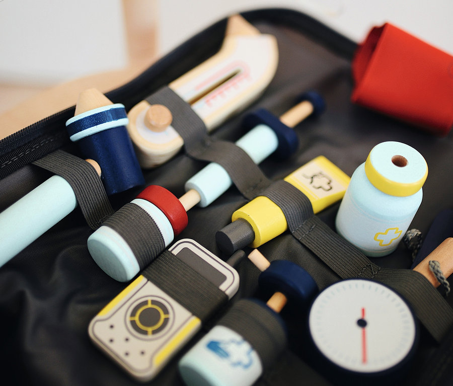 Offener small foot Notarzt-Rucksack mit hölzernen Spielzeug-Arztwerkzeugen und blauer Stoffmaske.
