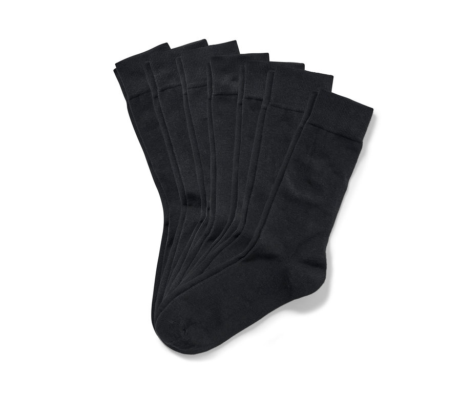 Sieben Paar Socken liegen auf einem weißen Hintergrund.
