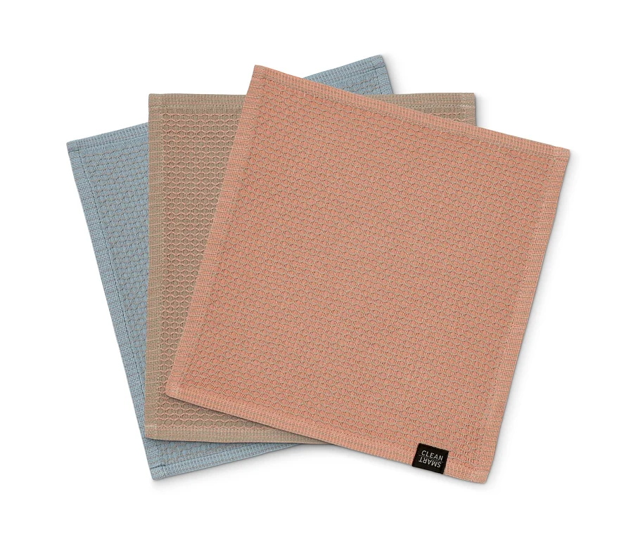 Drei Spültücher liegen übereinander, in blau, beige und rosa.