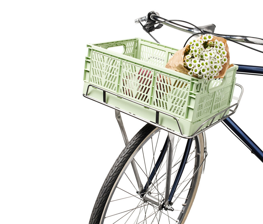 Zusammenklappbare urbane Fahrradkiste und Fahrrad-Vorderrad-Gepäckträger mit einem Strauß weißer Blumen.