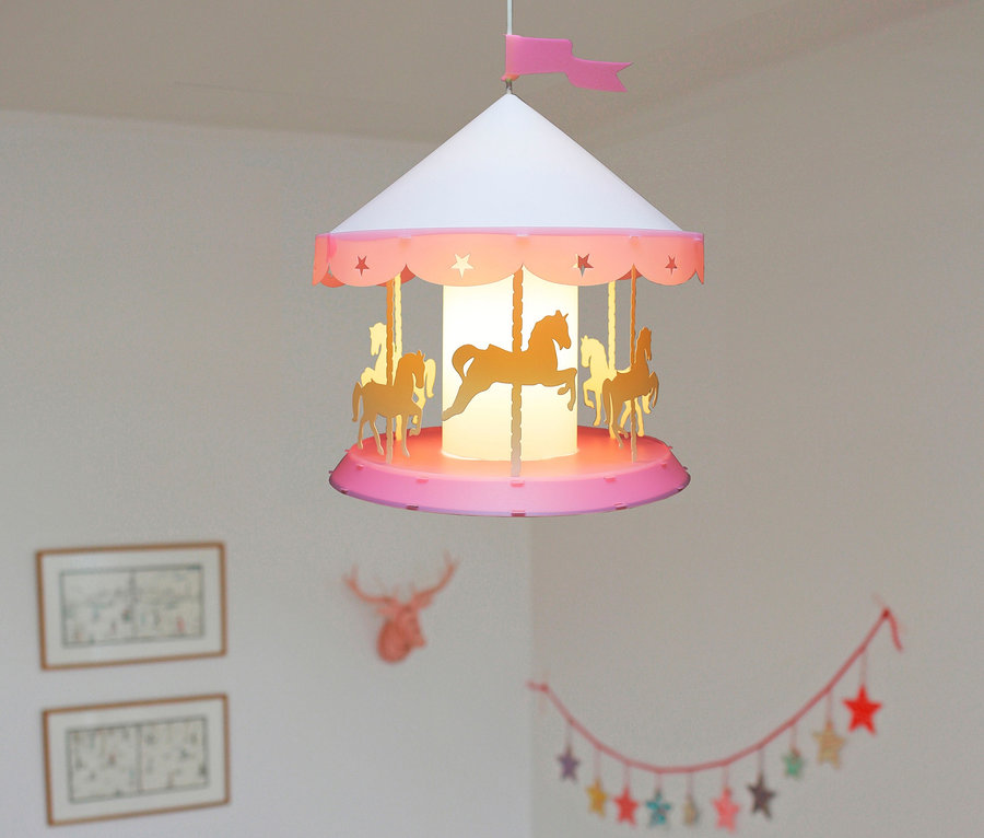 Kinderzimmer mit weißem Kinderbett, Holzschaukelpferd und Karussell-Deckenlampe.