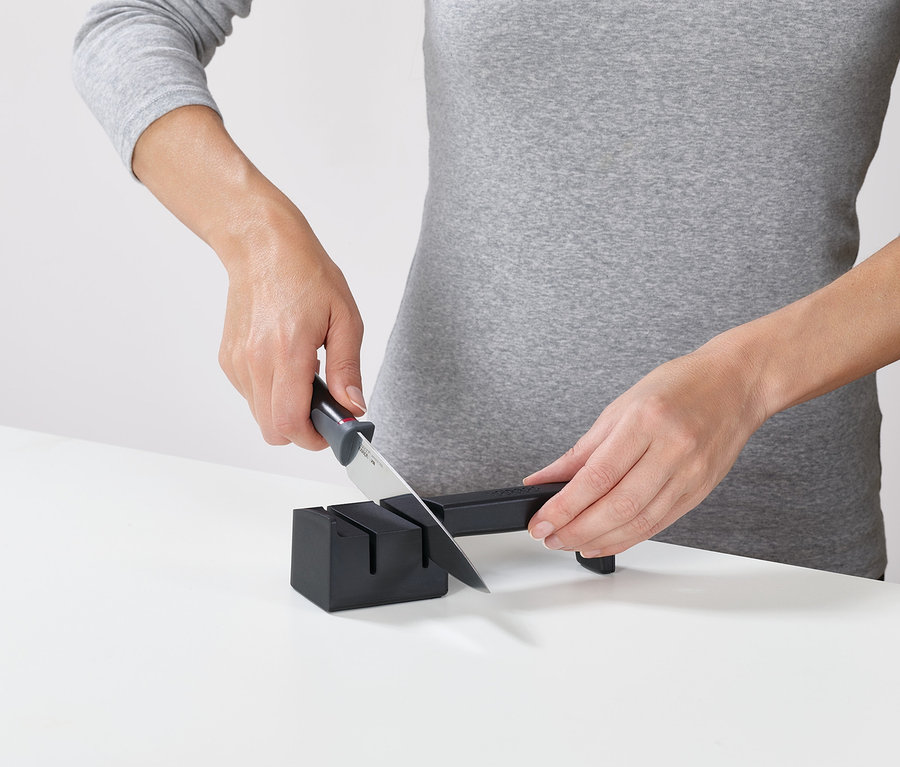 Frau schärft Messer mit Joseph Joseph Messerblock mit Schärfer »Elevate«.