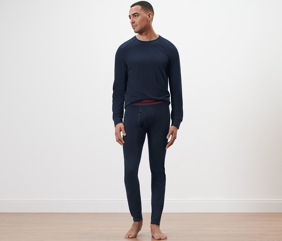 Mann steht in marineblauer langer Unterhose mit RWS-zertifizierter Wolle.