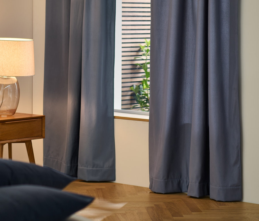 Blaue Thermovorhang verdecken das Fenster im Schlafzimmer.