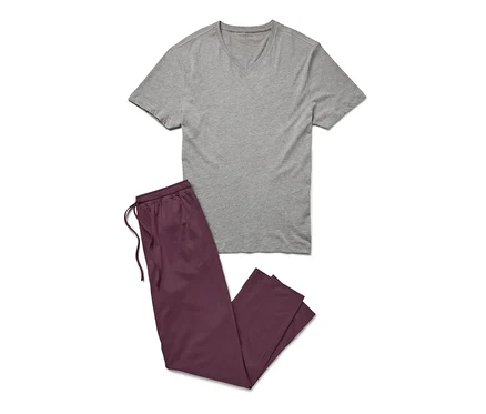 Grauer Pyjama mit burgunderroter Hose liegt auf einem weißen Hintergrund.