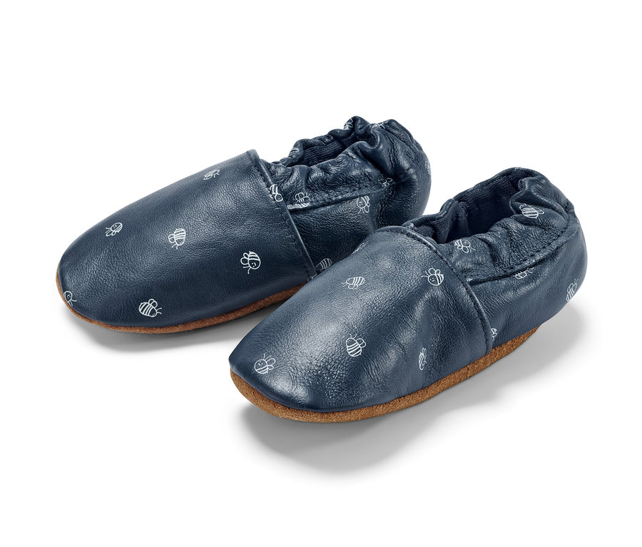 Zwei Baby-Lederschühchen mit Bienenmuster.