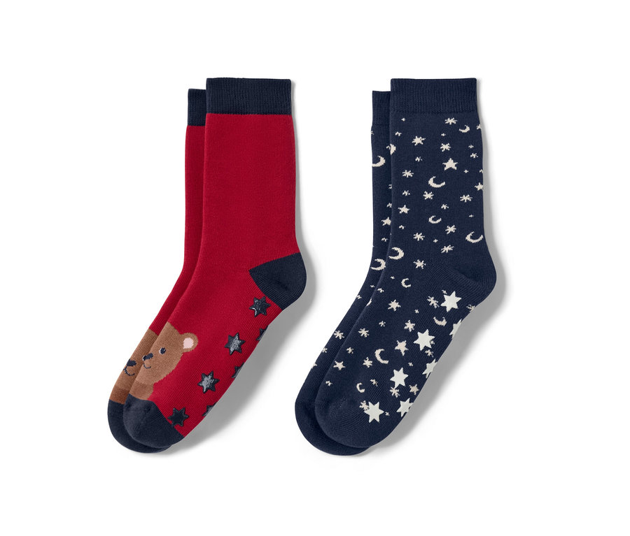 Zwei Paar Kinder-Antirutsch-Socken: ein Paar rot mit Bär, ein Paar dunkelblau mit Sternen und Monden.