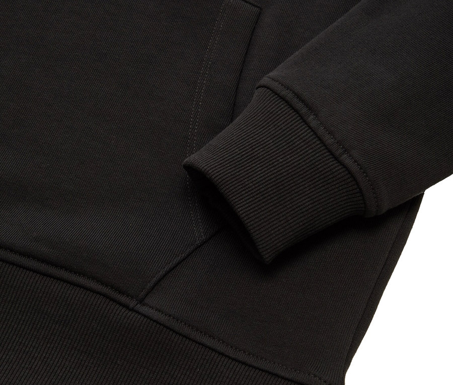 Detailaufnahme eines schwarzen Hoodies mit Rippbund und Bündchen.