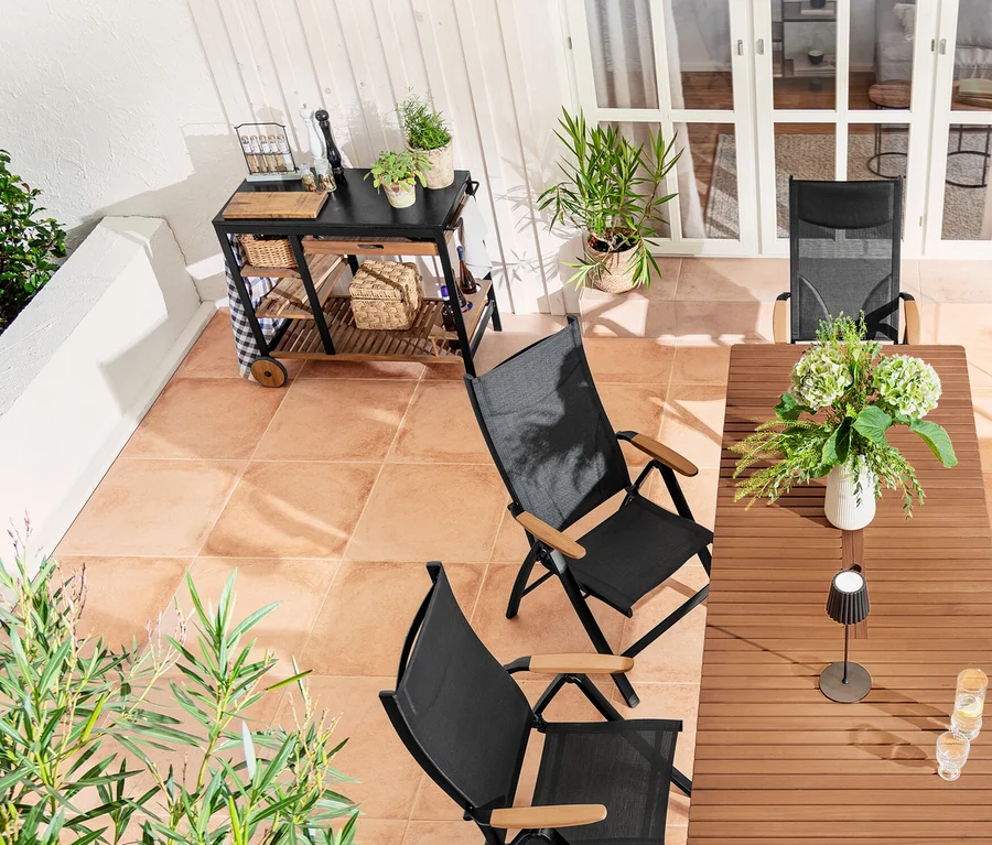 Außenterrasse mit Ausziehtisch »Elin«, 2-in-1-Dining-Bank-Liege »Elin«, Hochlehner, schwarzer LED-Akku-Outdoor-Stehleuchte und Pflanzkasten-Raumteiler »Tinus«.