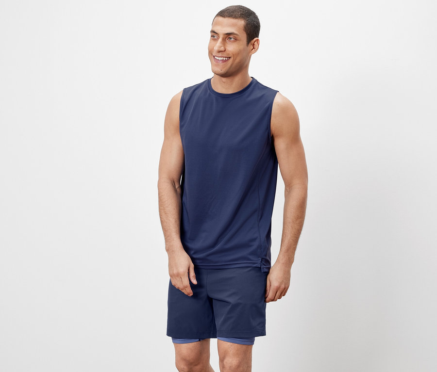 Mann trägt ein Tanktop und Shorts.