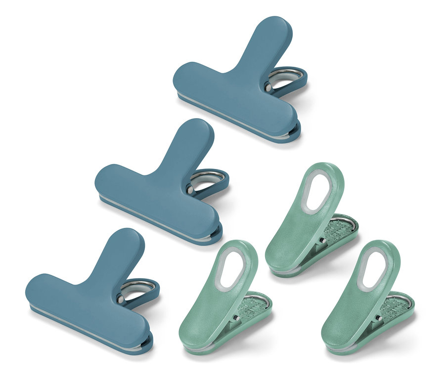 Draufsicht von drei blauen und drei grünen Chipstütenklammern auf einem weißen Hintergrund.