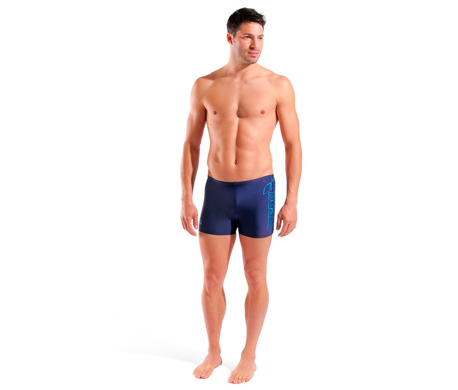 Mann steht und trägt eine arena Badehose Scratchy in Navy.
