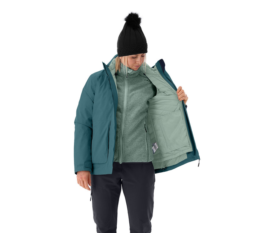 Frau öffnet eine CMP Damen-Multifunktionsjacke, trägt eine schwarze Bommelmütze, eine Fleecejacke und eine schwarze Hose.