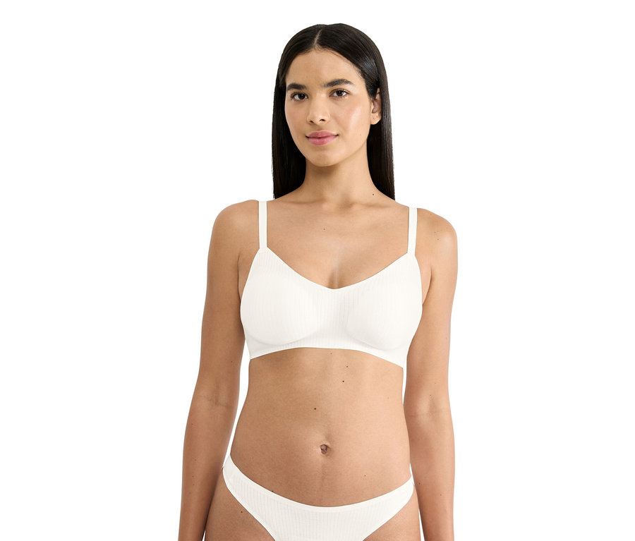 Frau trägt weißen gerippten BH und passende Unterwäsche.