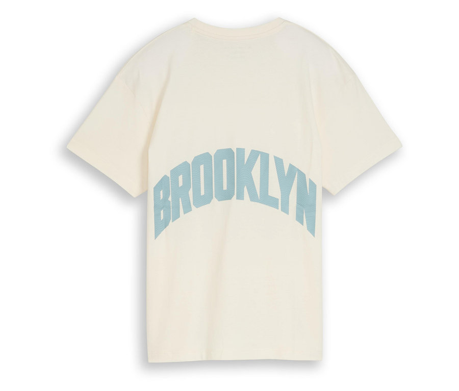 Nahaufnahme eines cremefarbenen T-Shirts mit blauem "Brooklyn"-Schriftzug auf der Rückseite.