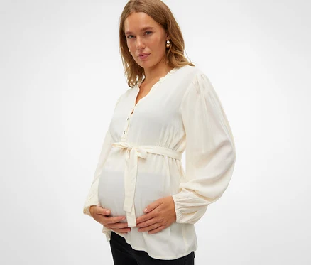 Schwangere hält ihren Bauch und trägt eine MAMALICIOUS MLMERCY LIA L/S WO TOP 2F NOOS.