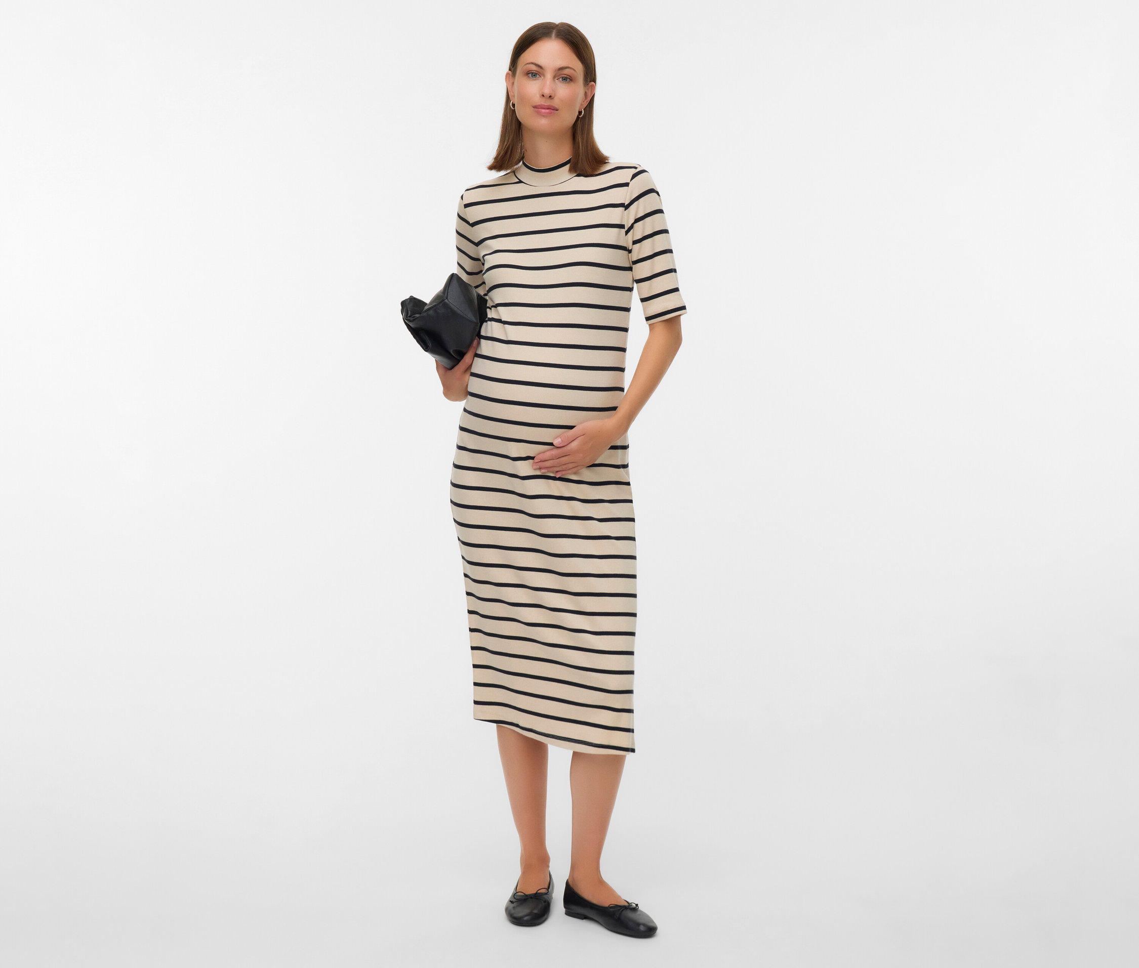 Schwangere Frau in gestreiftem Kleid hält eine schwarze Tasche.
