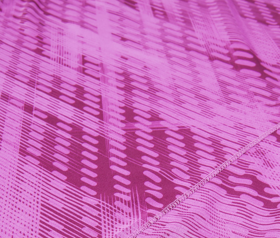 Nahaufnahme eines rosafarbenen Stoffes mit geometrischem Muster und dem FILA-Logo.