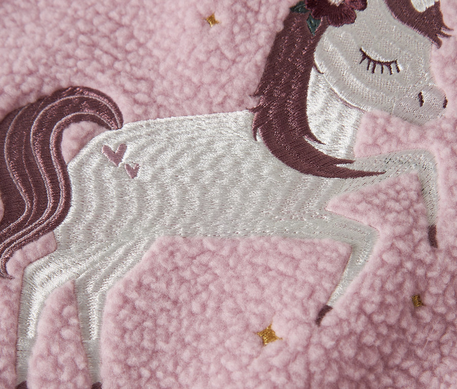 Nahaufnahme eines rosafarbenen Fleece-Stoffs mit einer gestickten Einhorn-Applikation.
