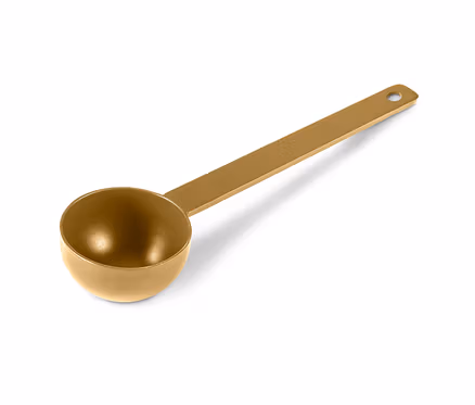 Goldenes Kaffeelot liegt auf weißer Oberfläche.