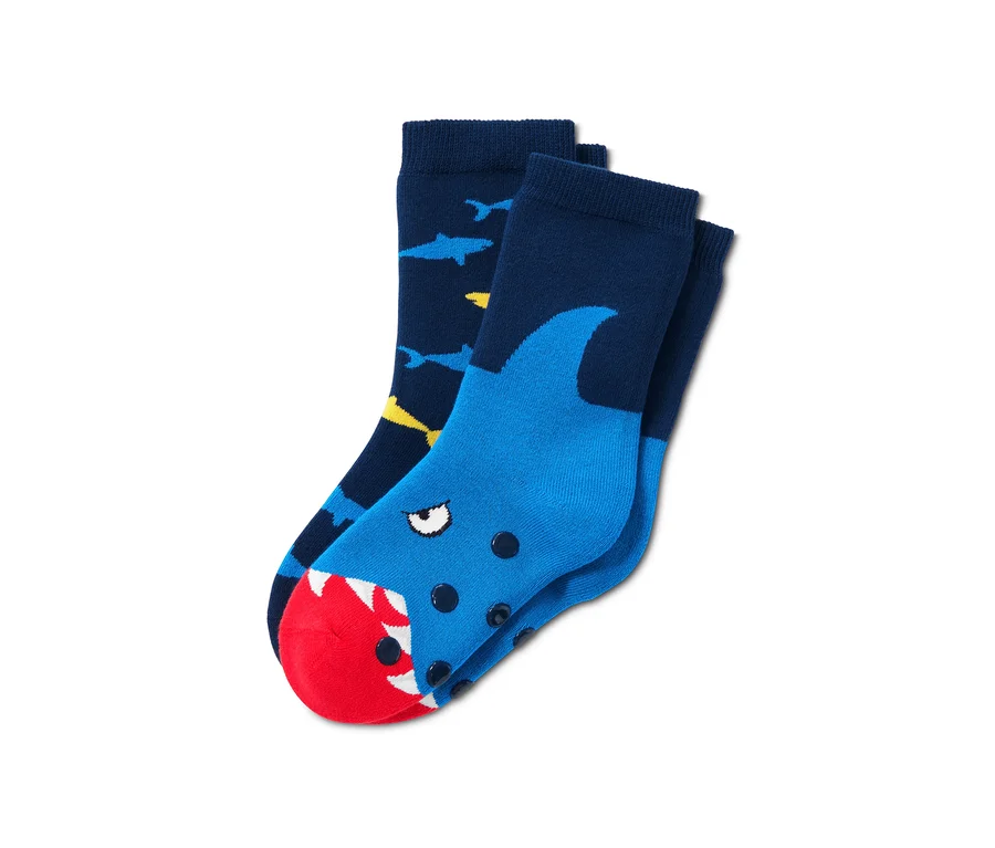Zwei Paar Antirutsch-Socken. Ein Paar ist dunkelblau mit gelben und blauen Haien. Das andere Paar ist blau mit einem Haikopf mit rotem Maul.