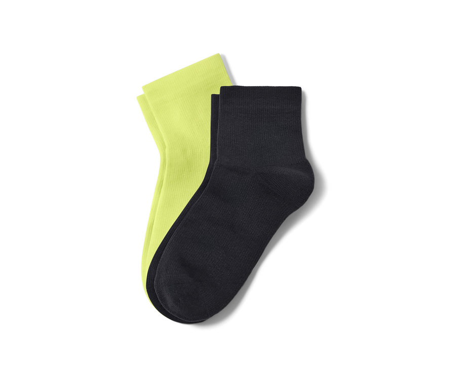 Zwei Paar kurze Sportsocken: ein Paar neon-grün, ein Paar schwarz.