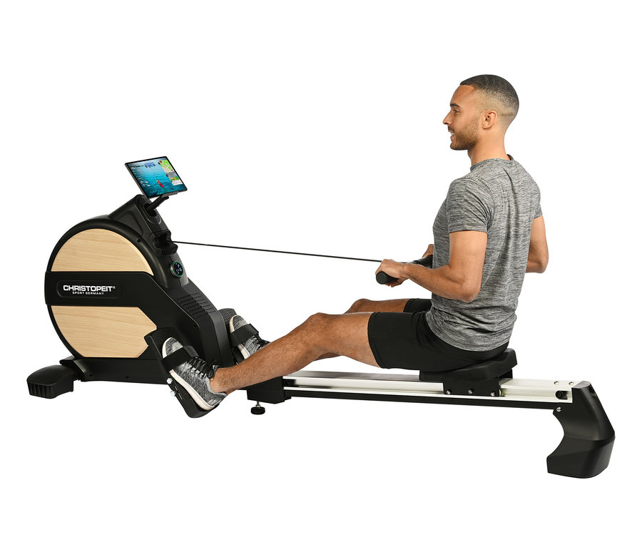 Mann trainiert auf dem Rowing Machine »Ergometer Vico«.