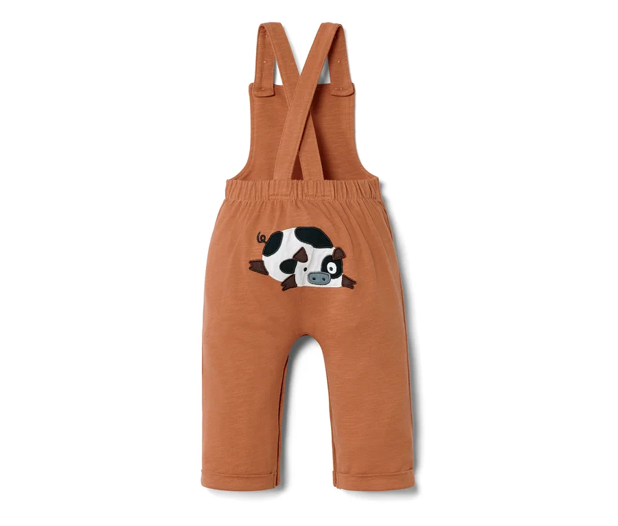 Eine braune Baby-Latzhose mit einem aufgenähten, liegenden Schwein.