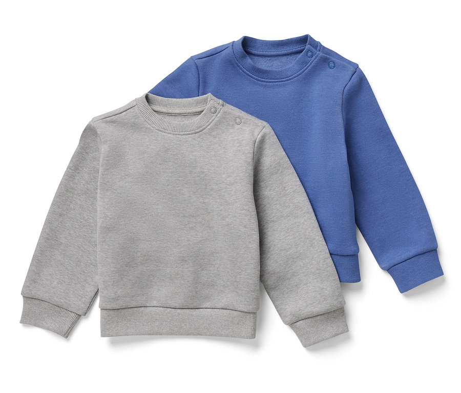 Zwei Kinder-Sweatshirts mit angerauter Innenseite, eines grau und eines blau, liegen übereinander.