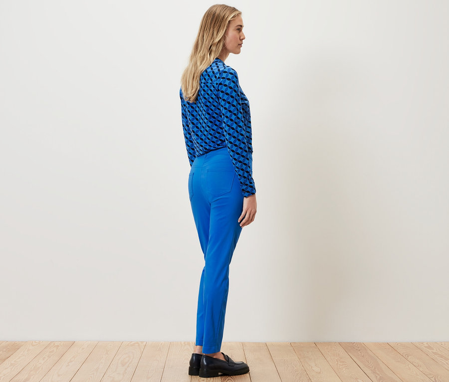 Frau steht seitlich und trägt eine kobaltblaue Bengalin-Hose.