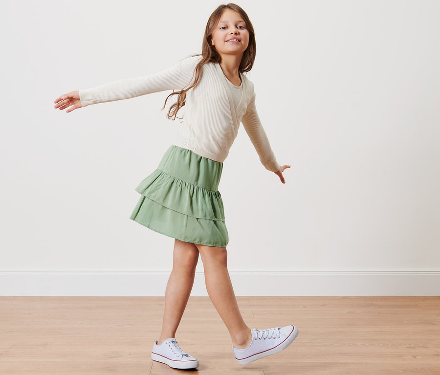 Mädchen posiert in einem Kinder-Stufenrock.