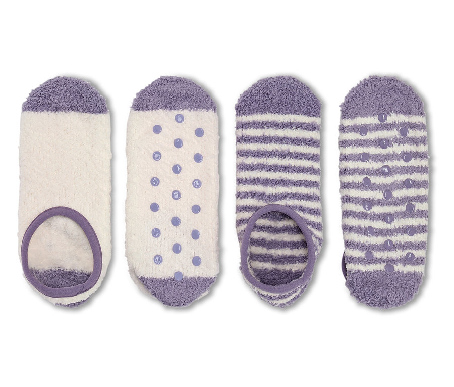 Vier Paar flauschige Socken in Weiß und Lila.